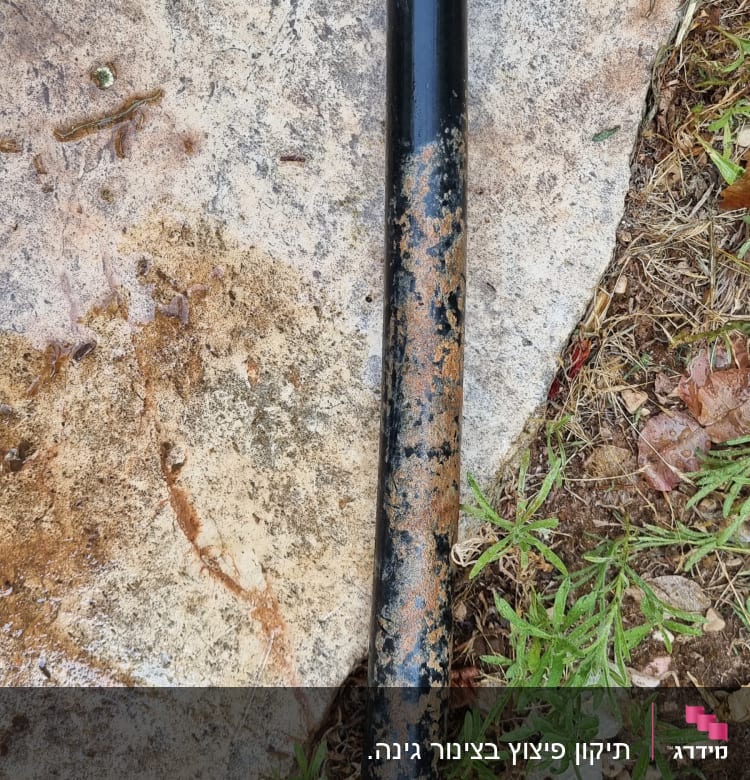 צינור מתכת חלוד על קרקע עם ברגים